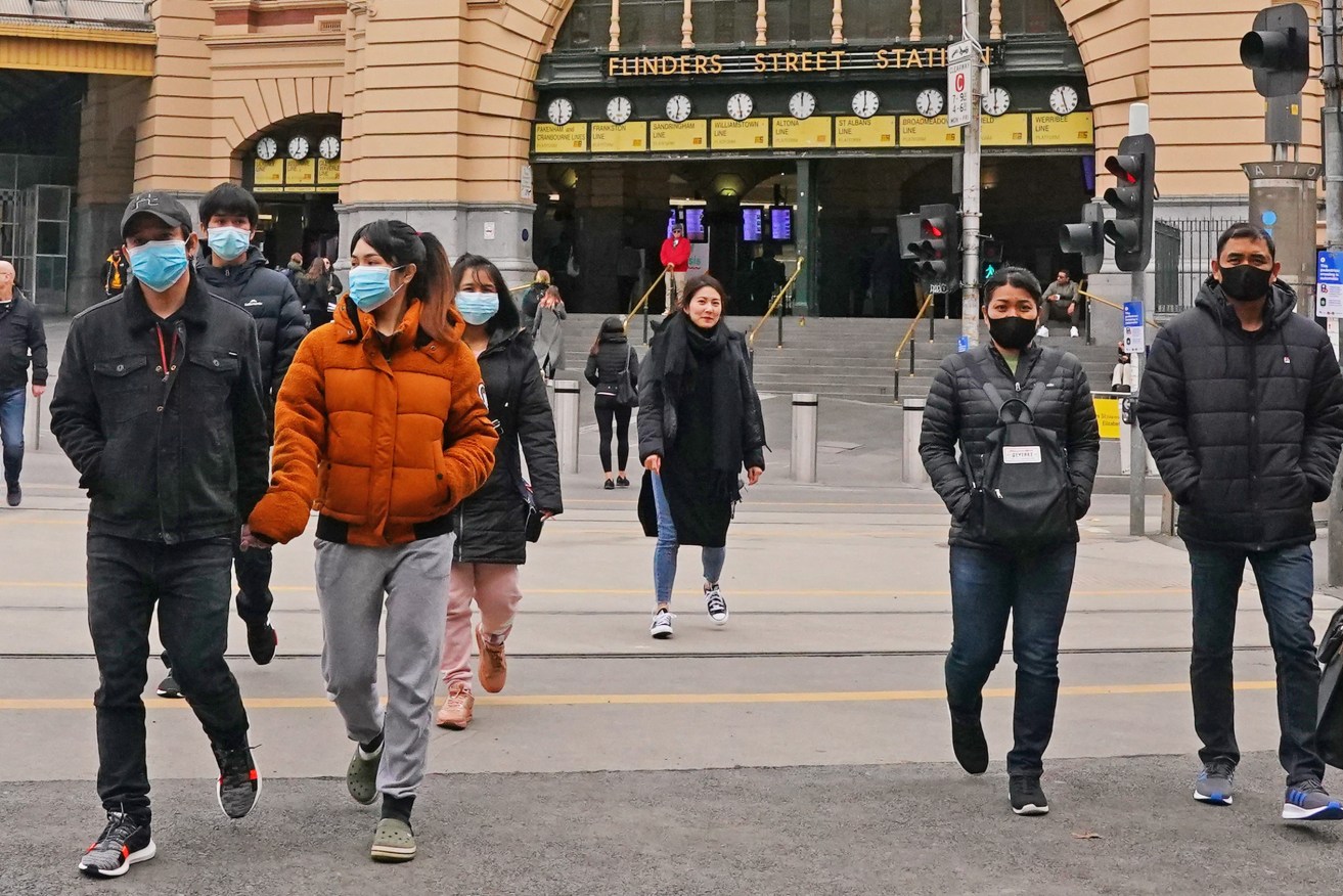 Masked commuters pictured outside Melbourne's Flinders Street Station. (Photo: AAP Image/Scott Barbour) 