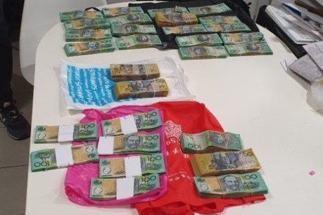 Brisbane woman charged with money laundering after police seize $260,000 in cash