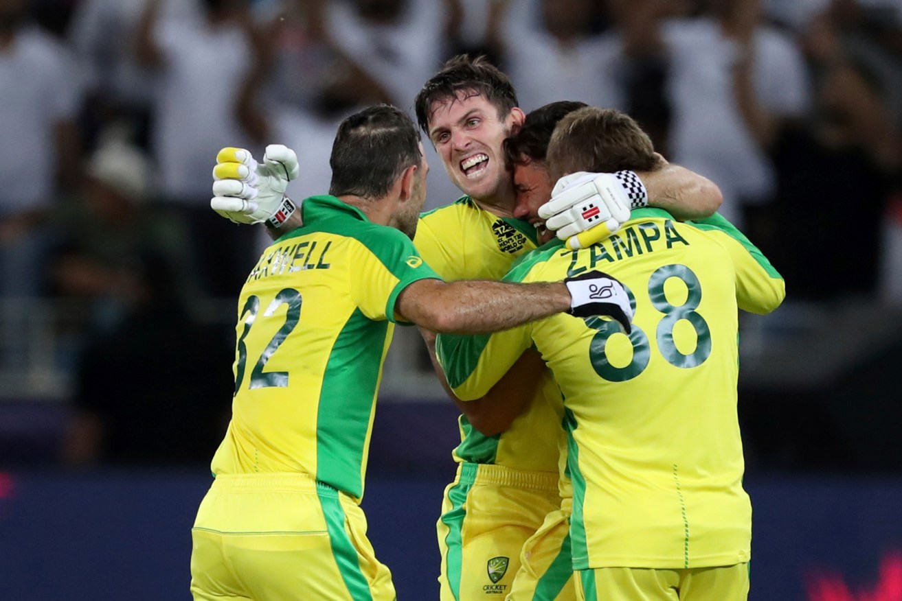 Australia's Glenn Maxwell, left, celebrates hitting a four to win the tournament, with his teammate Mitchell Marsh, second left, and Adam Zampa, 88, in the Cricket Twenty20 World Cup final match between Australia and New Zealand. (AP Photo/Kamran Jebreili)