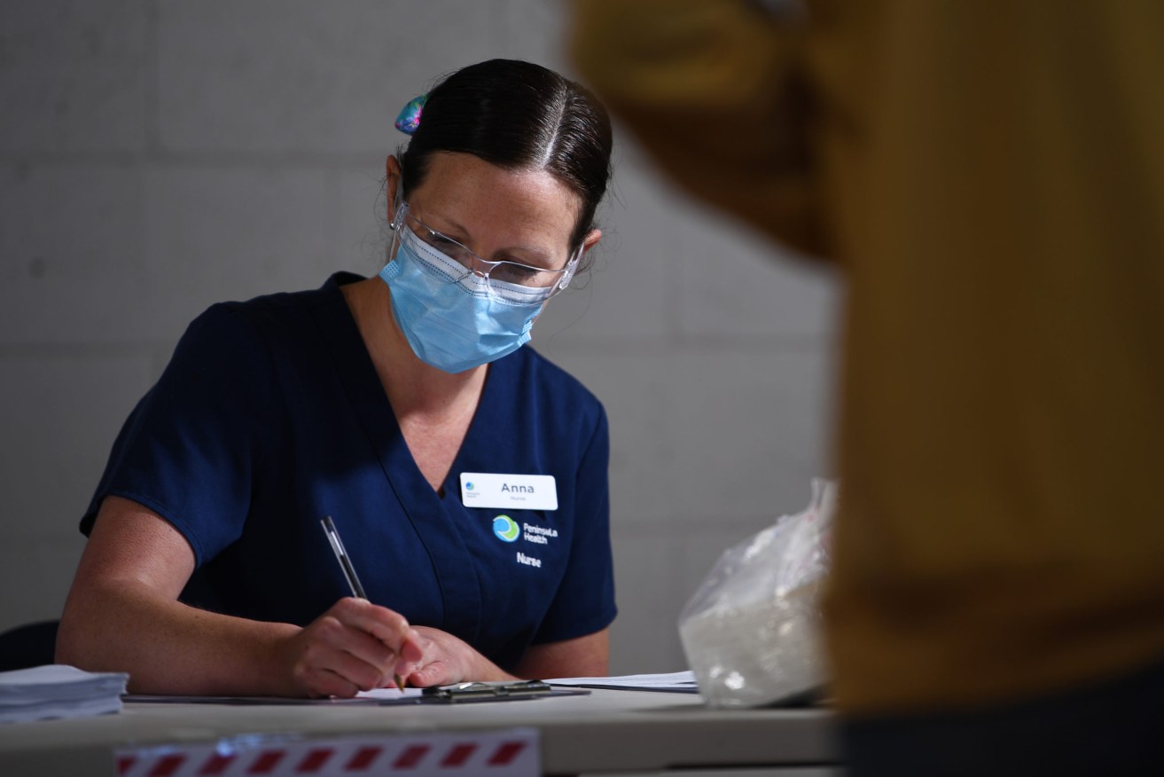 A healthcare workers records patients details before receiving coronavirus tests at a COVID19 testing facility. (AAP Image/James Ross) 