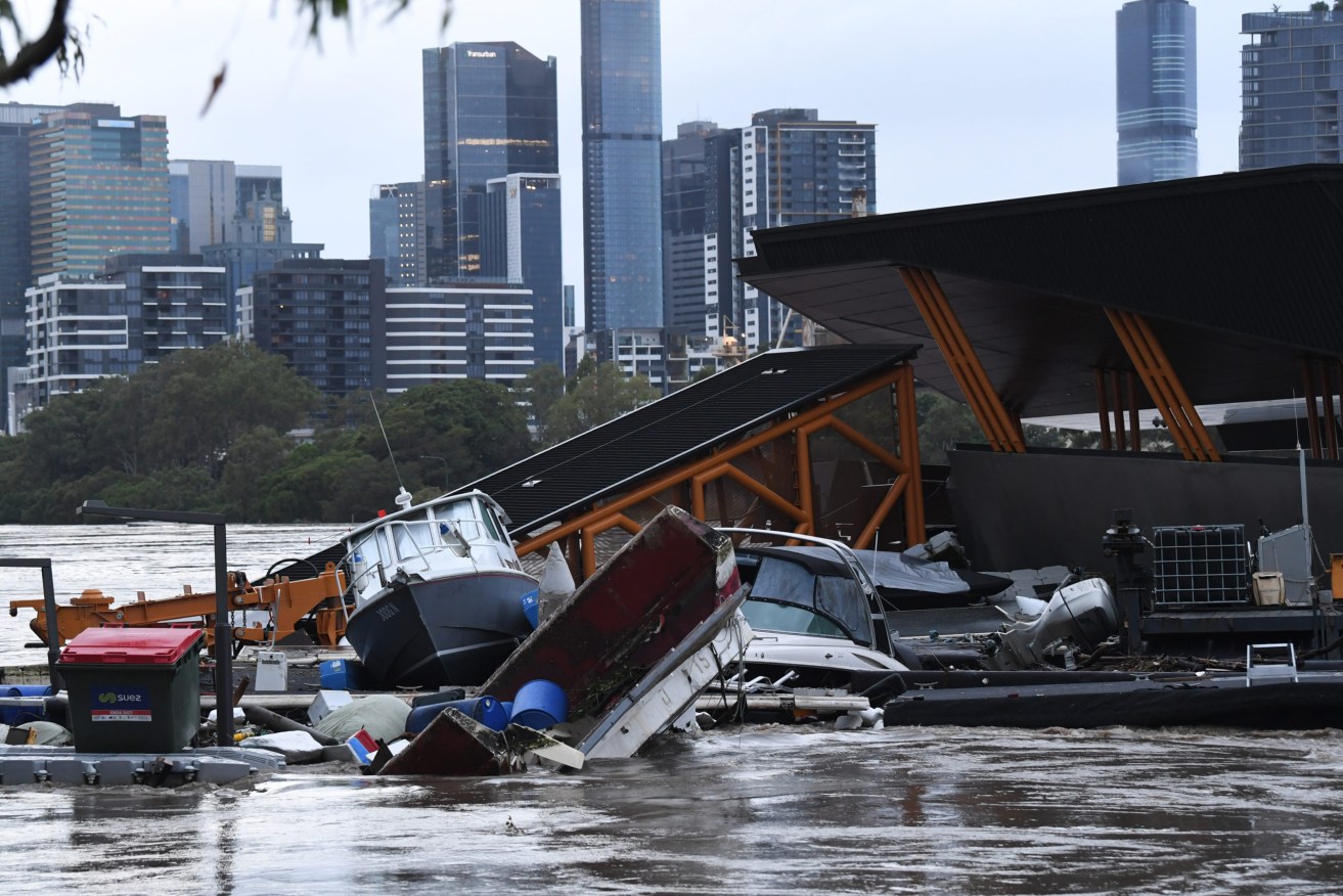 Boats and other debris are seen washed into the Milton ferry terminal on the Brisbane River in Brisbane, Monday, February 28, 2022.  Queensland's southeast is set to endure more wild weather as the state grapples with a days-long flood crisis. (AAP Image/Darren England) NO ARCHIVING