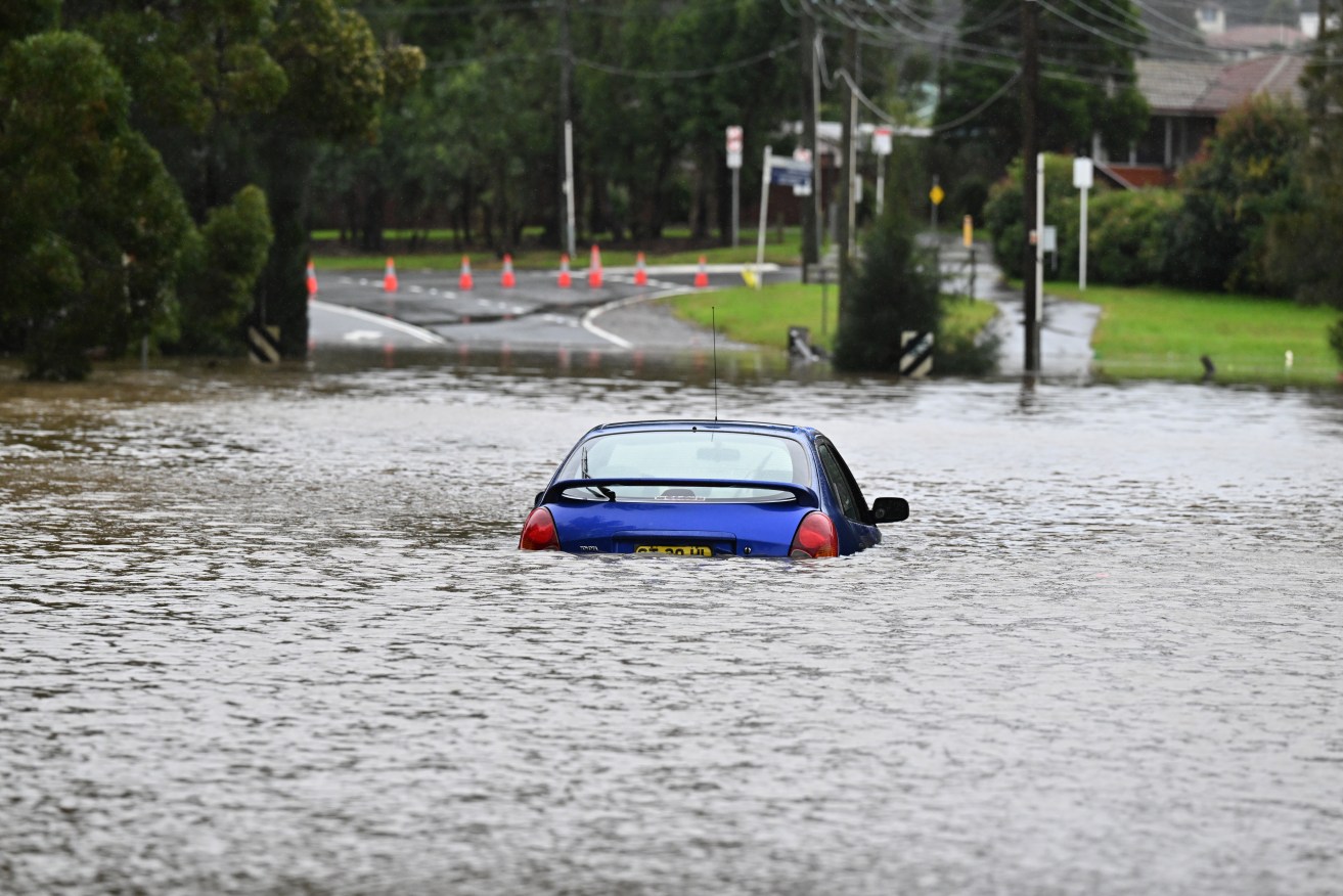 An abandoned car in floodwaters in Lansvale in Western Sydney on Sunday. (AAP Image/Mick Tsikas) 