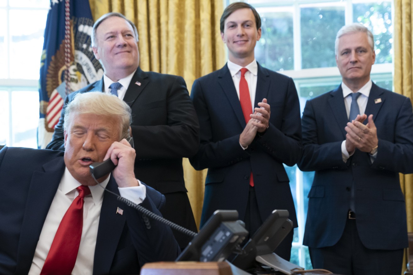 President Donald Trump talks on a phone call with the leaders of Sudan and Israel, as Secretary of State Mike Pompeo, left, White House senior adviser Jared Kushner, and National Security Adviser Robert O'Brien, applaud in the Oval Office of the White House, Friday, Oct. 23, 2020, in Washington. (AP Photo/Alex Brandon)